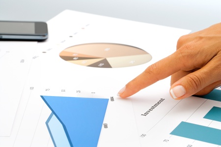 Close up of female hand pointing on investment documents 