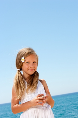 Close up portrait of sweet girl in white dress at seaside の写真素材