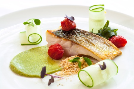 Macro close up of grilled seabass with cherry tomatoes and avocado の写真素材