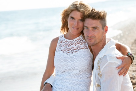 Close up portrait of attractive couple sitting on the beach の写真素材