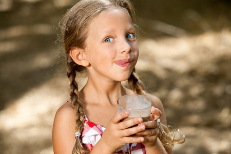 Close up portrait of expressive girl drinking chocolate milkshake.の写真素材
