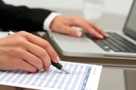 Extreme close up of female business hands working on accounting document.の写真素材