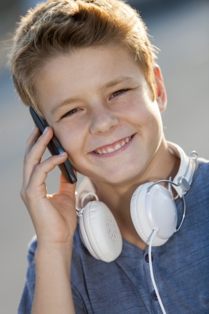 Close up portrait of teen boy talking on smart phone outdoors  の写真素材