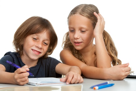 Young children doing homework together at desk.Isolated on white.の写真素材