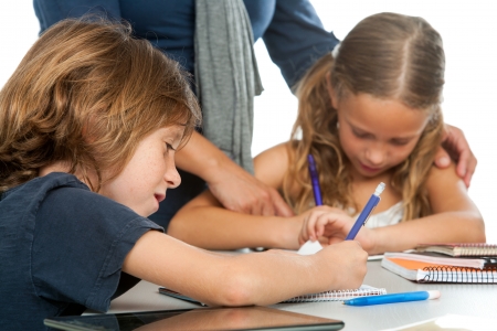 Close up of teacher supervising kids doing schoolwork.の写真素材