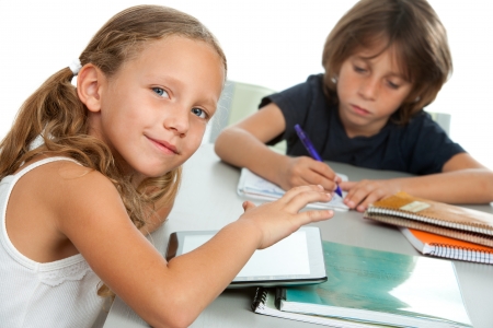 Close up portrait of two young kids doing schoolwork together at desk.Isolated.の写真素材