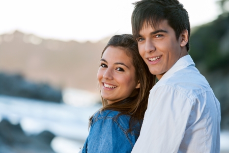 Close up portrait of young teen couple at sunset beach.の写真素材