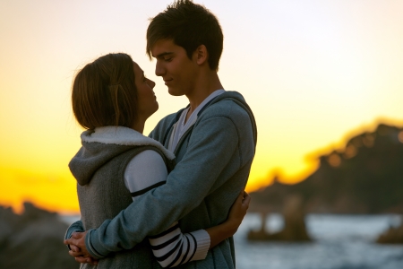 Silhouette portrait of young romantic couple at sunset.の写真素材