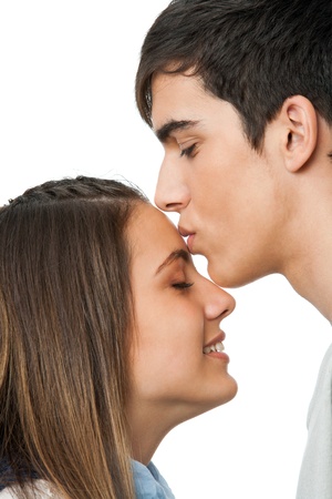 Close up of boy kissing girlfriend on forehead.Isolated on white.の写真素材