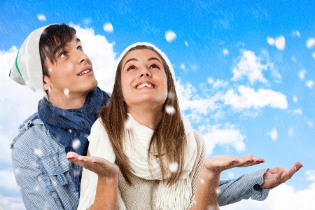 Close up portrait of winter couple playing with snowflakes.の写真素材