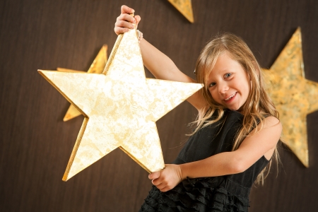 Portrait of cute girl holding big golden star の写真素材
