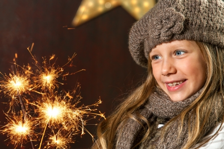 Close up portrait of cute girl looking at festive fire sparks の写真素材