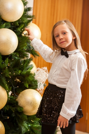 Close up portrait of little girl decorating christmas tree の写真素材