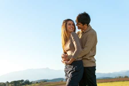 In love teen couple showing affection outdoors.の写真素材