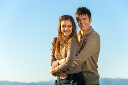 Portrait of cute teen couple embracing outdoors.の写真素材