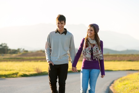 Young couple wandering along road in countryside.の写真素材