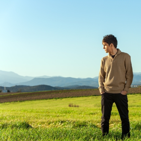 Portrait of young man standing in green field.の写真素材