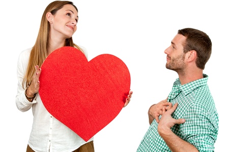 Close up portrait of couple playing around with big red heart symbol.Isolated on white background.の写真素材