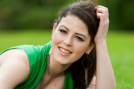 Close up portrait of pretty girl in green grass background.の写真素材