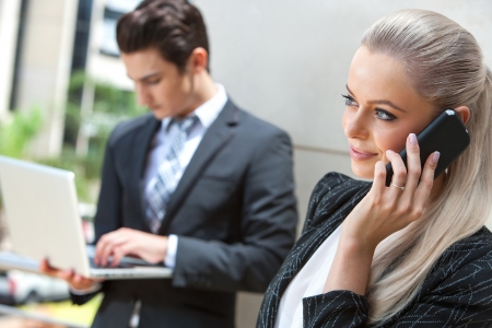 Close up portrait of elegant businesswoman talking on smart phone at outdoors meeting.の写真素材