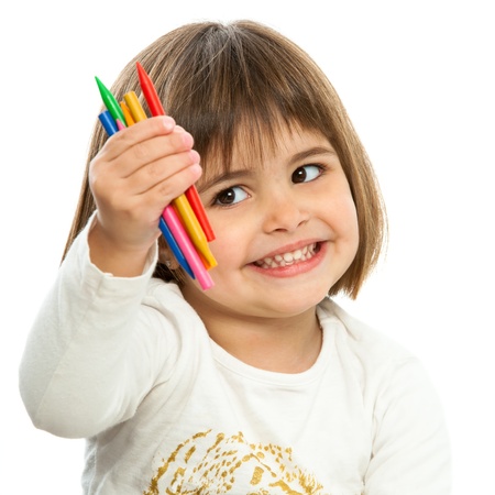 Cute girl showing color wax crayons.Isolated on white.の写真素材