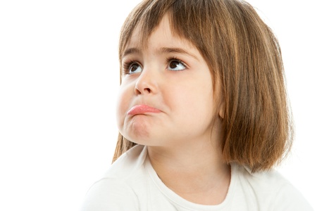 Portrait of small unhappy girl with funny face expression.Isolated.の写真素材