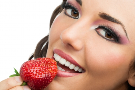Extreme close up of attractive woman eating strawberry.の写真素材