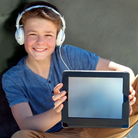 Close up portrait of cute boy showing blank tablet screen.の写真素材