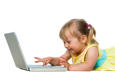 Portrait of little girl playing games on laptop.Isolated on white background.の写真素材