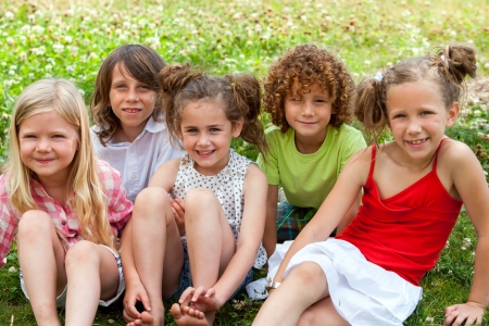 Group of youngsters sitting together in flower field.の写真素材