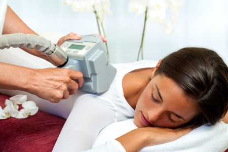 Therapist applying lipomassage on girls body in spa. の写真素材
