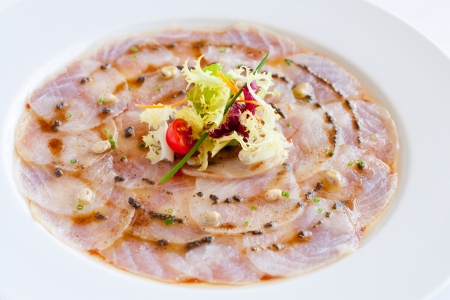 Close up of cod fish carpaccio on white plate.の写真素材