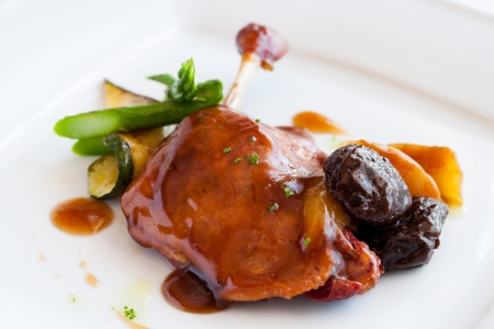 Close up of roasted duck thigh glazed with sweet fruit dressing.の写真素材
