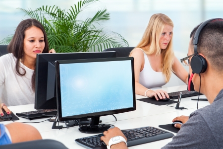 Young students training together on computers in office.の写真素材