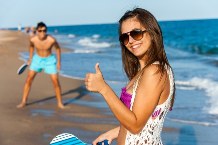 Cute teen beach tennis player doing thumbs up.の写真素材