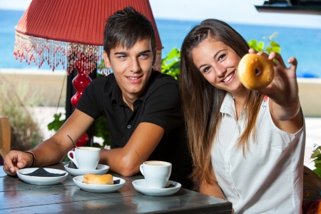 Close up of teen couple having breakfast at seaside.の写真素材