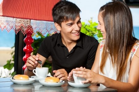 Close up portrait of teen couple enjoying breakfast in restaurant.の写真素材