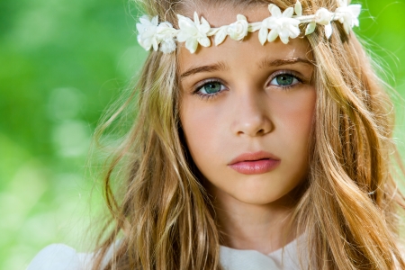 Extreme close up of cute girl with flower headband outdoors.の写真素材
