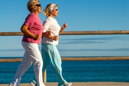 Action portrait of elderly women jogging together outdoors.の写真素材