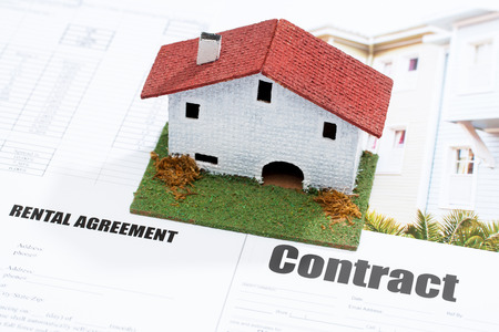 Macro close up of conceptual small toy house on contract documents の写真素材