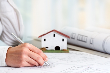 Close up of female hand working on real estate business documents.の写真素材