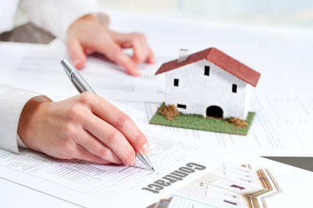 Close up of female hand reviewing real estate contract.の写真素材