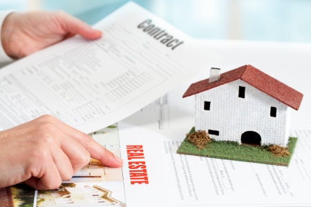 Close up of female hands reviewing real estate property documents.の写真素材