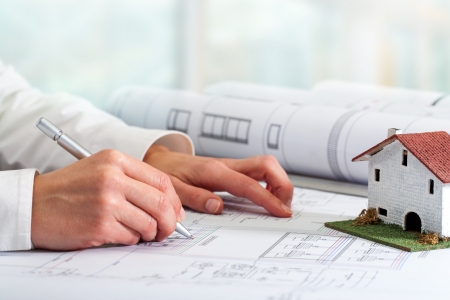 Close up of female hands working on architectural blueprints.の写真素材