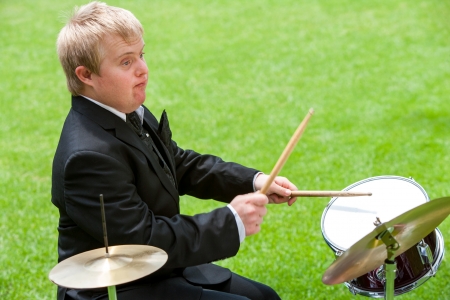 Portrait of handicapped drummer in suit playing outdoors.の写真素材