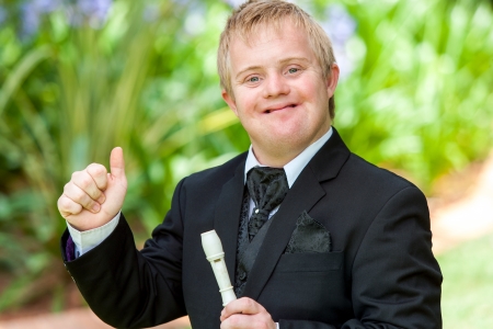 Portrait of handicapped musician in black suit doing thumbs up outdoors.の写真素材