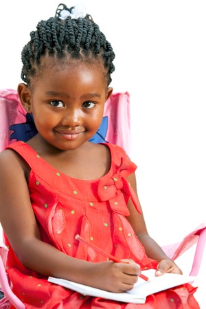 Close up portrait of cute little african girl with note book.Isolated on white background.の写真素材
