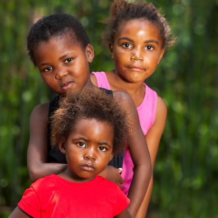 Close up facial portrait of three african girls together outdoors.の写真素材