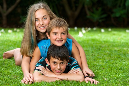 Portrait of kids paking human pile outdoors on grass.の写真素材