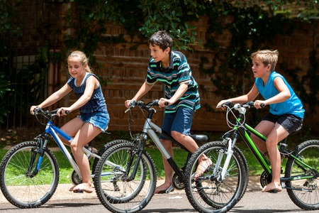 Motion shot of three kidscompeting with cycles outdoors.の写真素材